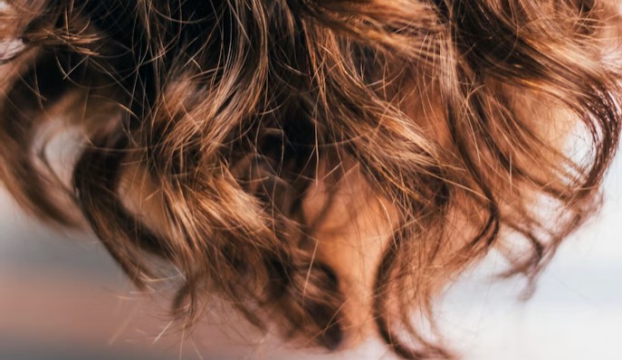 Close-up of dry wavy hair showing post-holiday heat and styling damage